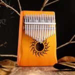 Pomarańczowa kalimba 17 tonów z wypalanym motywem słońca